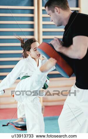 Stock Image - Taekwondo instructor working with girl. Fotosearch