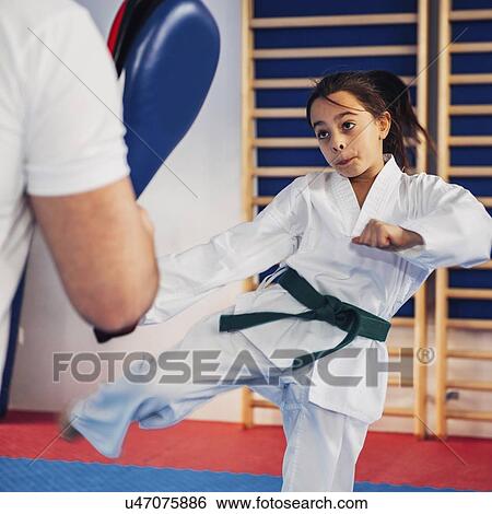 Stock Photograph - Taekwondo instructor working with girl. Fotosearch