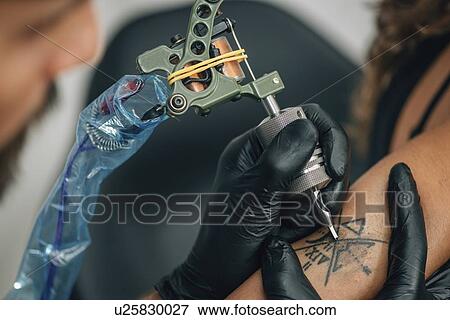 Tattoo artist at work View Large Photo Image Stock Photo - Tattoo artist at work. Fotosearch