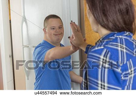 Teen boy with Down Syndrome high-fiving friend View Large Photo Image Picture - Teen boy with Down Syndrome high-fiving friend. Fotosearch
