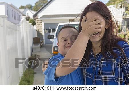 Stock Image - Teen who has Down Syndrome with his friend. Fotosearch