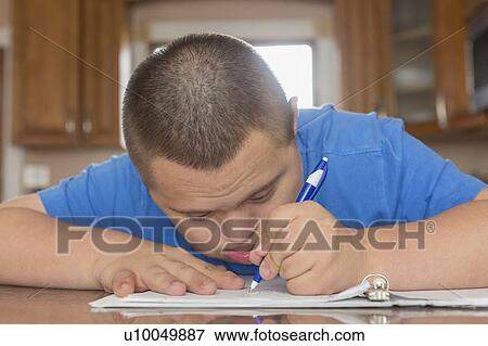 Stock Photo - Teen with Down Syndrome studying. Fotosearch