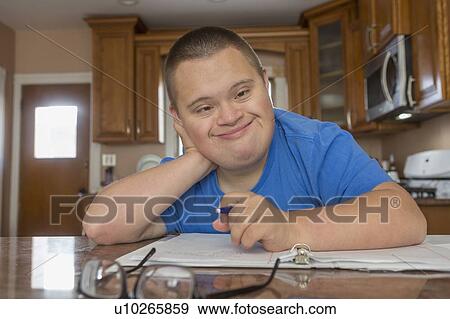 Stock Photo - Teen with Down Syndrome studying. Fotosearch