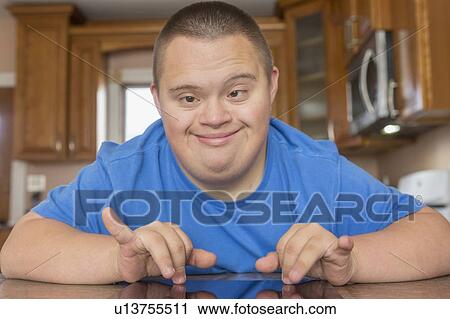 Teen with Down Syndrome using digital tablet View Large Photo Image Stock Image - Teen with Down Syndrome using digital tablet. Fotosearch