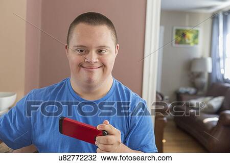 Teen with Down Syndrome using his phone View Large Photo Image Stock Image - Teen with Down Syndrome using his phone. Fotosearch