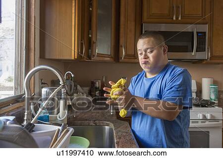 Teen with Down Syndrome washing up View Large Photo Image Stock Image - Teen with Down Syndrome washing up. Fotosearch
