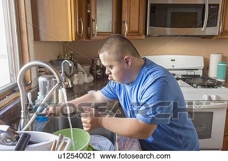 Teen with Down Syndrome washing up View Large Photo Image Stock Image - Teen with Down Syndrome washing up. Fotosearch