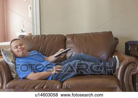 Stock Photo - Teen with Down Syndrome watching TV. Fotosearch