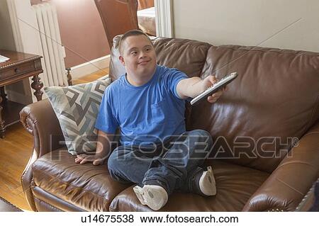 Teen with Down Syndrome watching TV View Large Photo Image Stock Photo - Teen with Down Syndrome watching TV. Fotosearch