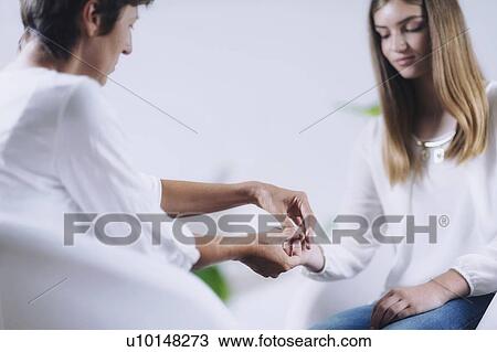 Stock Image - Teenage girl having theta healing therapy. Fotosearch