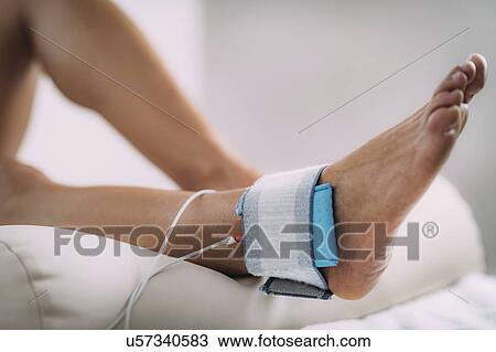 Stock Image - TENS treatment for ankle. Fotosearch