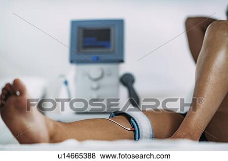 Stock Photo - TENS treatment for knee. Fotosearch