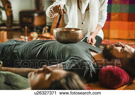 Stock Image - Tibetan singing bowl therapy. Fotosearch