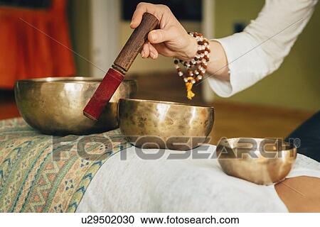 Stock Image - Tibetan singing bowl therapy. Fotosearch