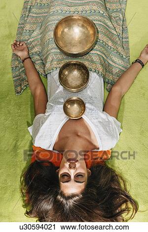 Stock Image - Tibetan singing bowl therapy. Fotosearch