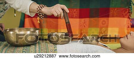Stock Photo - Tibetan singing bowl therapy. Fotosearch