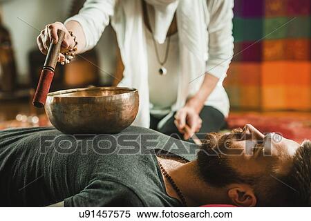Stock Photography - Tibetan singing bowl therapy. Fotosearch