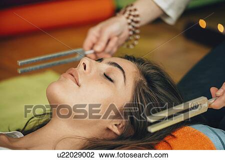 Stock Image - Tuning fork sound therapy. Fotosearch