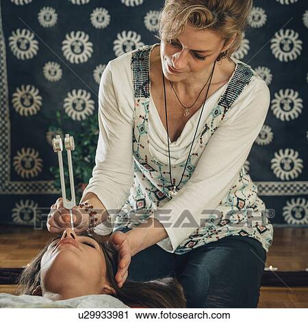 Stock Image - Tuning fork sound therapy. Fotosearch