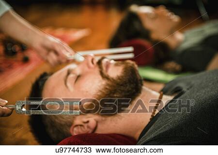 Stock Image - Tuning fork sound therapy. Fotosearch