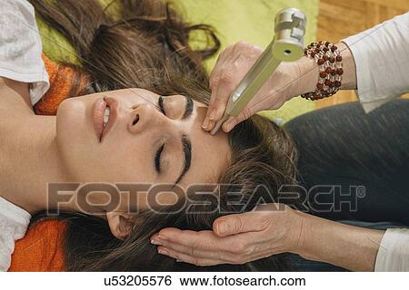 Stock Photograph - Tuning fork sound therapy. Fotosearch