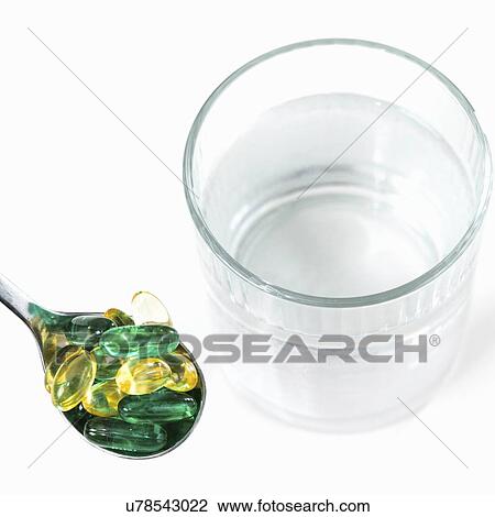 Stock Image - Vitamin pills and glass of water. Fotosearch