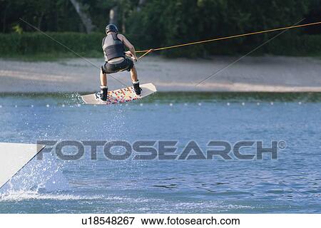 Stock Photo - Wakeboarding performing stunt. Fotosearch