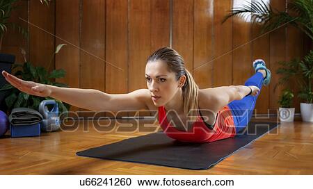 Stock Image - Woman doing back extension exercises. Fotosearch