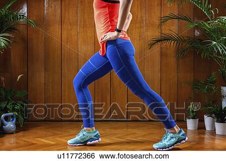 Stock Photograph - Woman doing lunges. Fotosearch