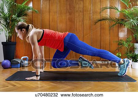 Stock Image - Woman doing mountain climbers. Fotosearch