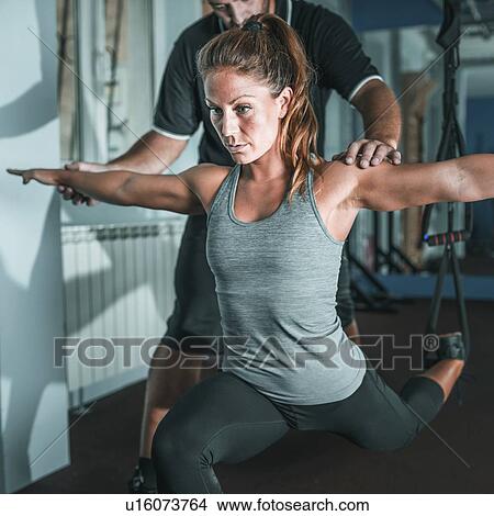Picture - Woman doing TRX workout. Fotosearch