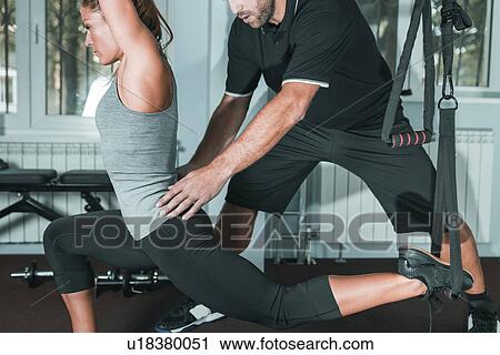 Stock Image - Woman doing TRX workout. Fotosearch