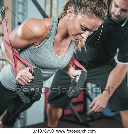 Stock Image - Woman doing TRX workout. Fotosearch