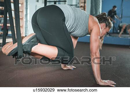 Stock Photo - Woman doing TRX workout. Fotosearch