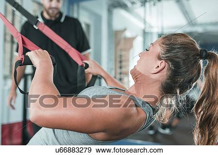 Stock Photo - Woman doing TRX workout. Fotosearch