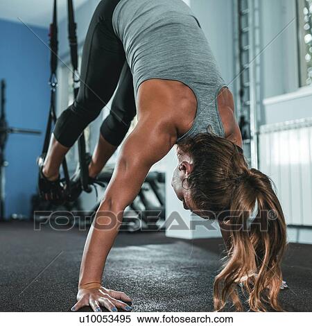 Stock Photography - Woman doing TRX workout. Fotosearch