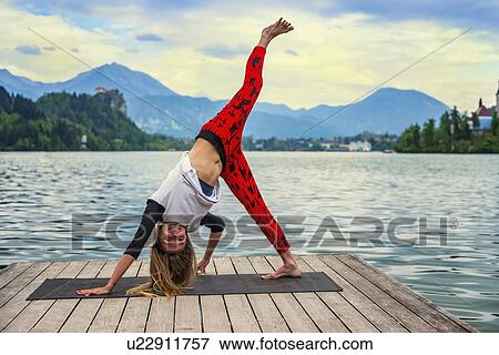 Stock Photo - Woman doing yoga by a lake. Fotosearch