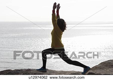 Woman doing yoga next to the sea View Large Photo Image Stock Image - Woman doing yoga next to the sea. Fotosearch