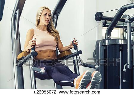 Stock Image - Woman exercising in the gym. Fotosearch