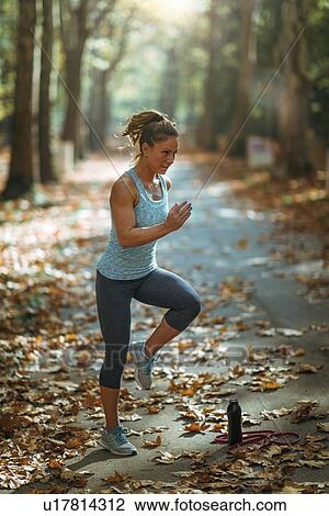 Stock Image - Woman exercising outdoors. Fotosearch