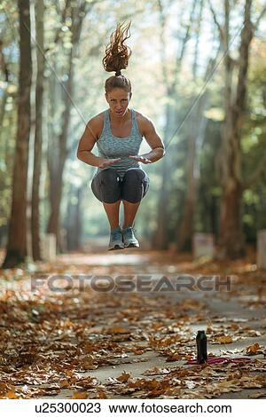 Stock Image - Woman exercising outdoors. Fotosearch