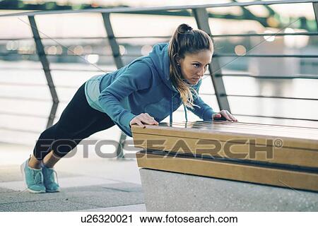 Stock Image - Woman exercising outside. Fotosearch