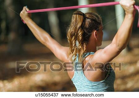Woman exercising with elastic band outdoors View Large Photo Image Stock Photo - Woman exercising with elastic band outdoors. Fotosearch