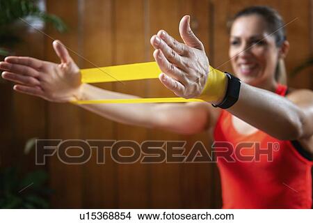 Picture - Woman exercising with resistance band. Fotosearch