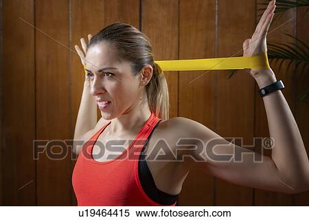 Stock Photography - Woman exercising with resistance band. Fotosearch