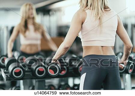 Stock Photo - Woman exercising with weights. Fotosearch