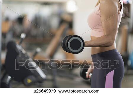Stock Photo - Woman exercising with weights. Fotosearch