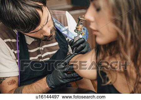 Woman getting a tattoo View Large Photo Image Stock Photo - Woman getting a tattoo. Fotosearch