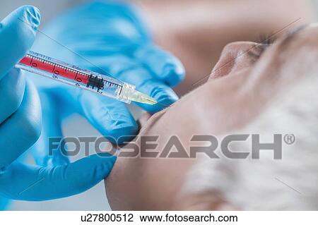 Stock Image - Woman having hyaluronic acid injections. Fotosearch