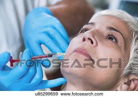 Stock Photo - Woman having hyaluronic acid injections. Fotosearch